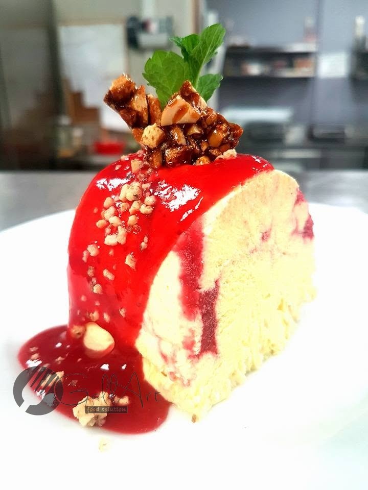 Parfait înghețat cu coulis de zmeură și migdale caramelizate.